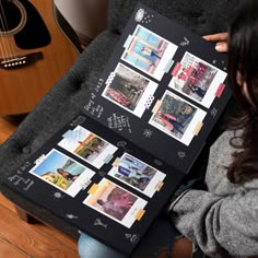 a woman sitting on a couch holding up a black board with pictures