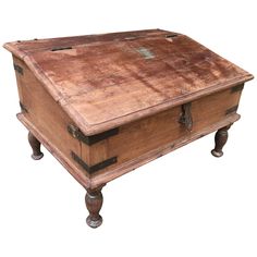 an old wooden box with metal handles on it's legs and feet, sitting on top of a white surface