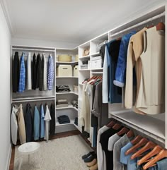 an organized closet with clothes and shoes on hangers, carpeted flooring and white walls