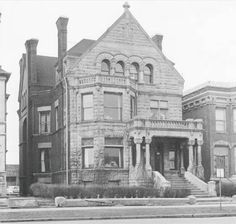 an old brick building with many windows on the front and second story is shown in this black and white photo