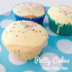 three cupcakes with white frosting and sprinkles on a blue plate