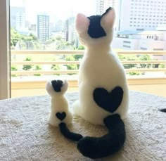 two stuffed cats sitting on top of a table