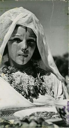 an old black and white photo of a woman wearing a veil