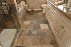 a bathroom with tile flooring and white cabinets