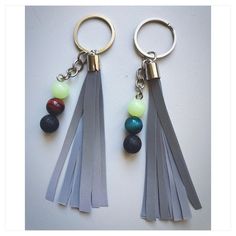 two keychains with tassels and beads on them sitting next to each other