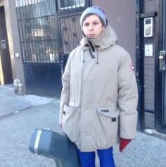 a man standing in front of a building holding a suitcase