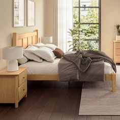 a bed room with a neatly made bed and wooden floors