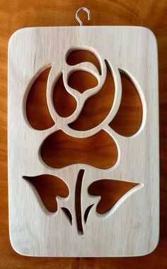 a wooden ornament with an image of a flower on the front and side