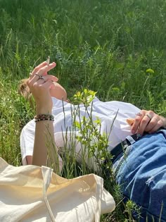 a woman laying in the grass with her hand up