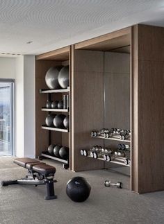 an exercise room with various equipment in the corner and sliding glass doors leading to outside