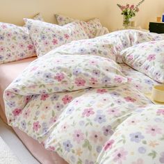 an unmade bed with flowers on it