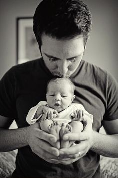 a man holding a baby in his arms and looking at the camera with an instagramr