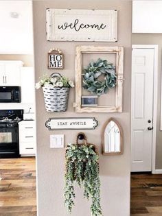 a wall with some plants and pictures hanging on it's side in a kitchen