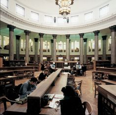 several people are sitting at desks in a library