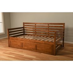 a wooden bed frame with two drawers on the bottom, and a window in the background