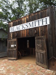 an old wooden building with a sign that says blacksmith