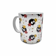 a white coffee cup with black and yellow monsters on it