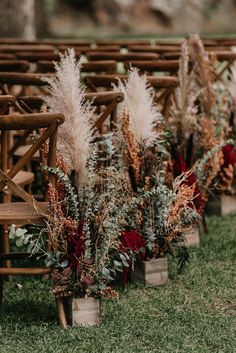 rows of wooden chairs with flowers and greenery on them