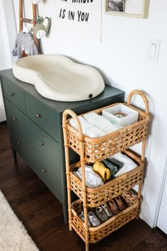 a bathroom with a sink and wicker baskets on the shelf next to it's drawers