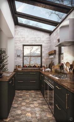 a kitchen with green cabinets and tile flooring under a skylight above the sink