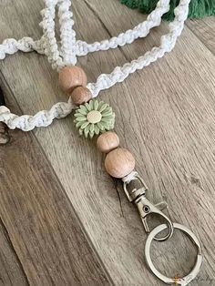 a white and green lanyard with wooden beads on it, attached to a pair of scissors