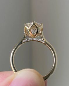 a hand holding a gold ring with diamonds on it