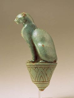 a statue of a cat sitting on top of a vase