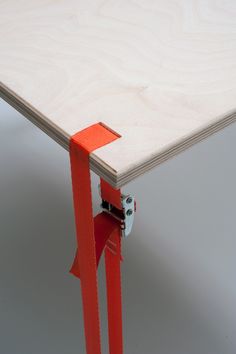 an orange piece of tape is attached to the edge of a table