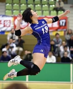 a woman jumping in the air to hit a volleyball