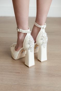 a woman's legs wearing high heels with flowers on them