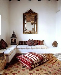 a living room filled with lots of furniture and pillows on top of a white couch