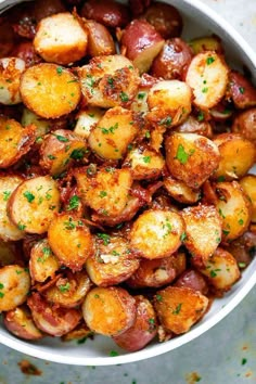 a white bowl filled with potatoes covered in seasoning