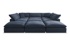 a large blue sectional couch with pillows on it's back and the seat facing outward