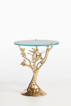 a gold tree table with glass top