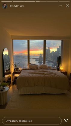 a bedroom with a large window overlooking the water and cityscape in the background