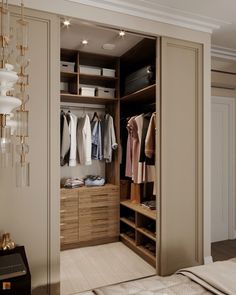 an open closet with clothes hanging on the shelves and drawers, along with other items