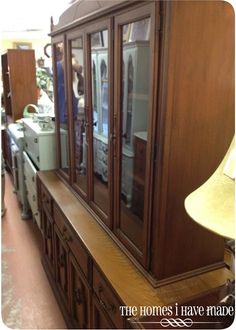 an antique china cabinet with glass doors in a store