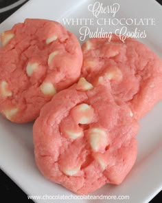 three pink cookies are on a white plate