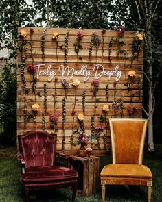 an old chair sitting next to a wooden wall with flowers on it and the words truly madly deeply written in cursive writing