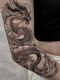 a woman's arm with a dragon tattoo on the left side of her body