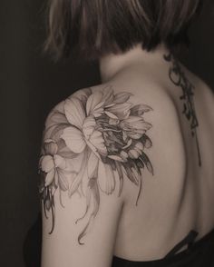 the back of a woman's shoulder with flowers on it