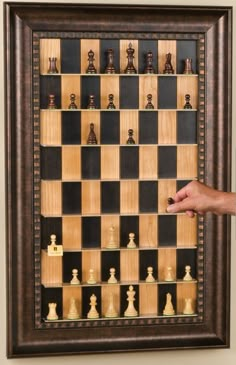 a man standing next to a framed chess board