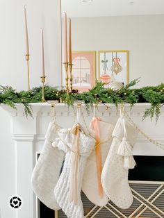 stockings hanging from a mantel with candles and decorations