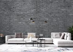 a living room with grey brick walls and white furniture in the center, along with a rug on the floor