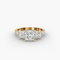 three stone diamond ring in yellow gold with diamonds on the sides and side stones around the band