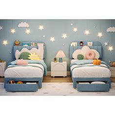 two children's beds in a bedroom with blue walls and white stars on the ceiling