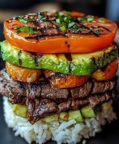 a stack of grilled meat and vegetables on top of rice