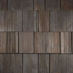 a close up view of wood shingles on a house's roof, showing the brown