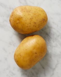 two potatoes sitting on top of a white counter