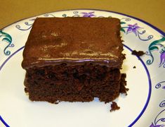 a piece of chocolate cake sitting on top of a white and blue flowered plate